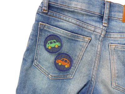 Mini Oldtimer Patches orange und grün auf Kinderhose aufgebügelt, dunkelblauer Jeansstoff Ø 4 cm, Auto-Bügelflicken Kinderhosen reparieren handmade Berlin