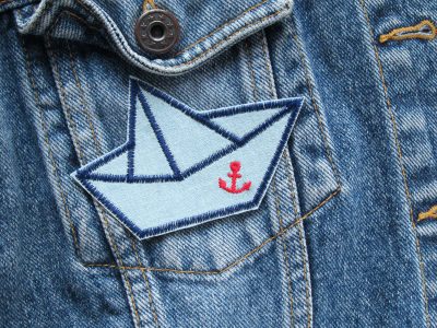 Papierschiffchen Jeansflicken 9 x 6 cm auf Jeansjacke aufgebügelt, hellblauer Jeansstoff mit Papierboot und rotem Anker, Bügelflicken handmade Berlin Piratenbande