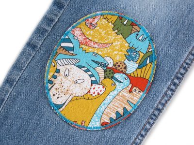 Bunte Dino-Knieflicken auf Kinderhose aufgebügelt, heller Baumwollcanvas 10 x 12 cm mit bunten Dinosauriern, XL Bügelflicken Kinderhosen reparieren Piratenbande Berlin