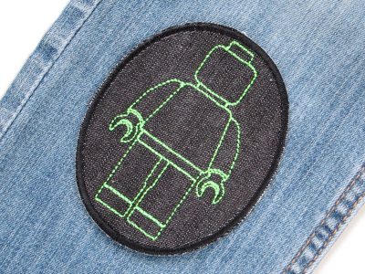 Neongrüne Bausteinmännchen-Knieflicken auf Kinderhose aufgebügelt, schwarzer Jeansstoff 8 x 10 cm mit neongrünen Spielfiguren, Hosenflicken Kinderhosen reparieren Piratenbande Berlin
