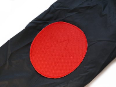 Rote Cordura-Aufnäher auf Regenhose aufgenäht, wasserdichtes Cordura 10 x 12 cm mit gesticktem Stern, Regenhosen reparieren Flicken Piratenbande Berlin