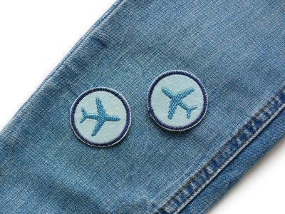 Flugzeug Mini Patches auf Kinderhose aufgebügelt, hellblauer Jeansstoff Ø 4 cm mit blau-grauem Flugzeug, Bügelflicken handmade Berlin Piratenbande