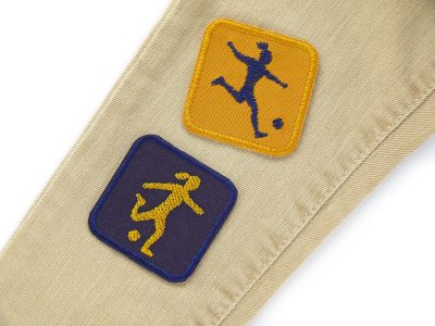 Patches mit Fußballspielerinnen auf eine Jeanshose aufgebügelt – Fußballerin Patches senfgelb und dunkelblau 5,5 x 5,5 cm auf Jeans, Bügelflicken Kinderhosen reparieren handmade Berlin Piratenbande